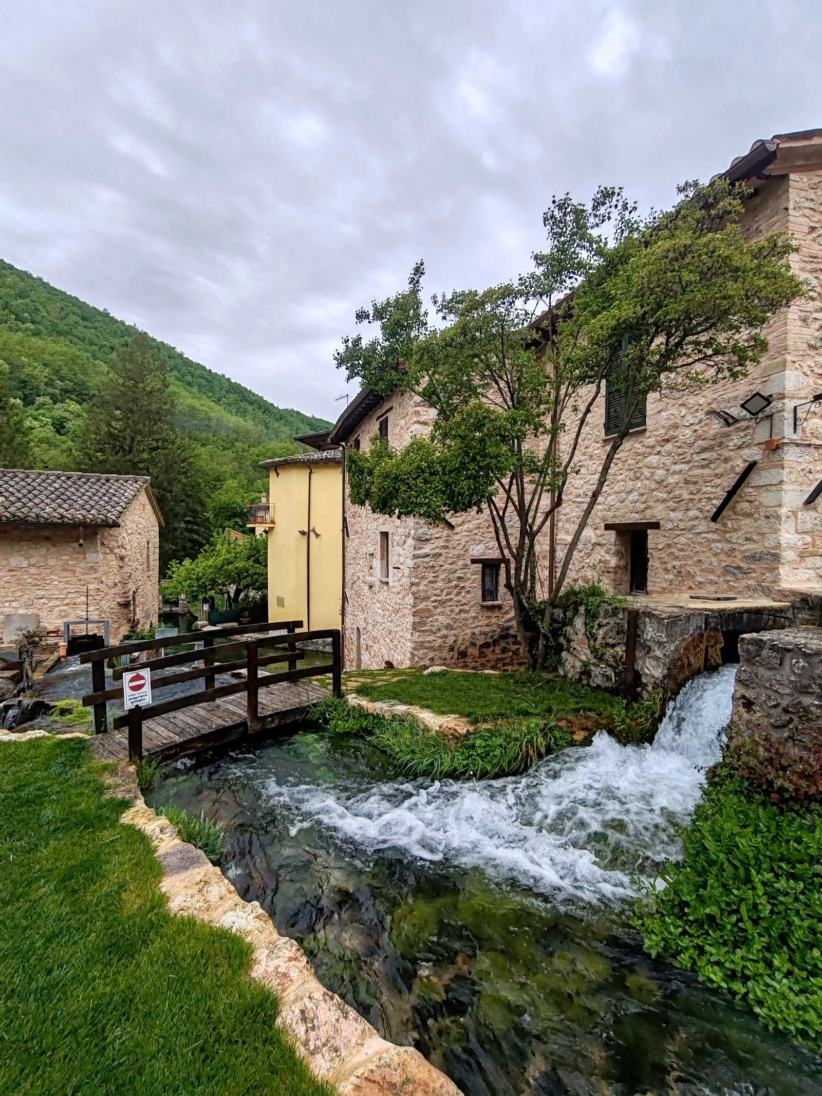 Cascading water, a wooden bridge and stone houses in Rasiglia, Umbria