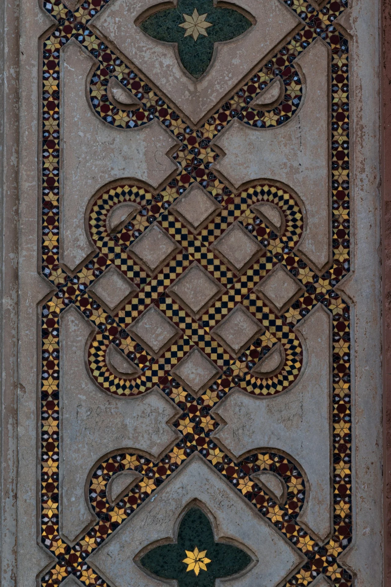 An architectural mosaic in Orvieto with star motifs, geometric patterns and carved pale stone