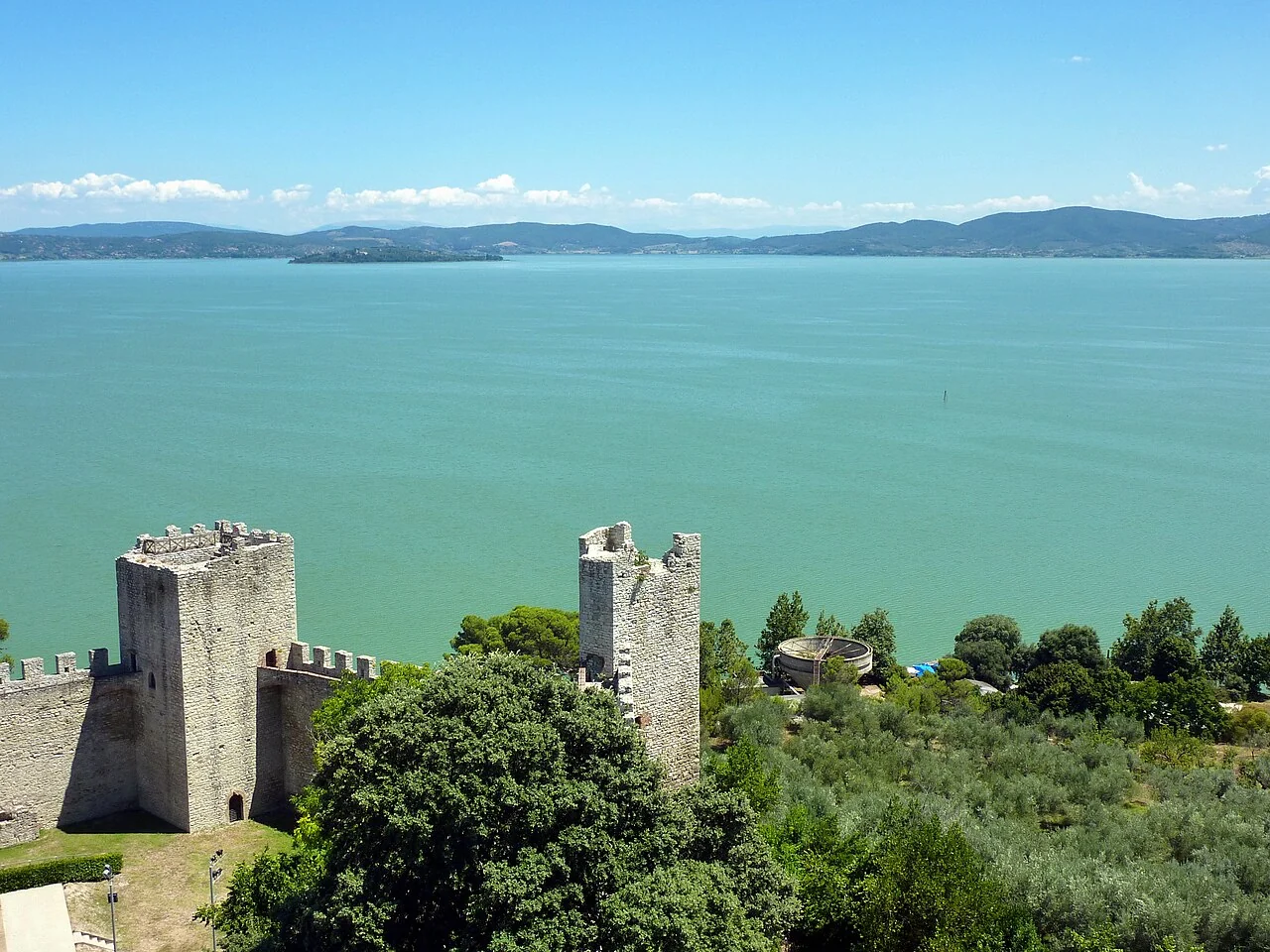 Stone fortress towers overlooking the blue waters of Lake Trasimeno at Castiglione del Lago