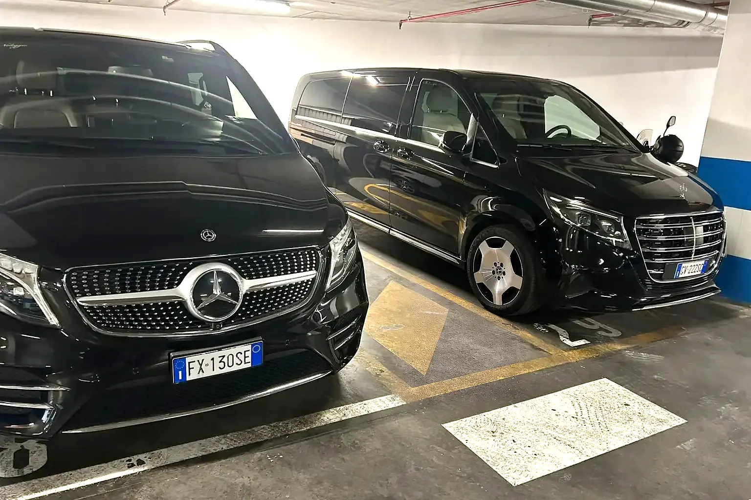 Two real black Mercedes-Benz V-Class executive vans from the operating fleet