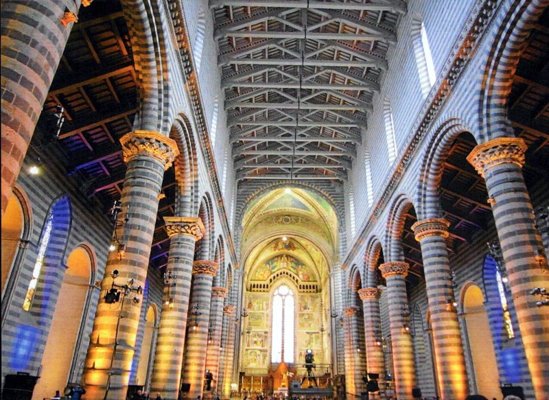 Interior of Orvieto Cathedral, with striped stone columns and the central nave